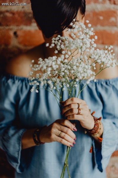 手拿鲜花和马克杯的中年妇女图片