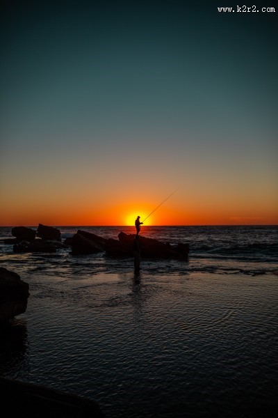拿着鱼竿钓鱼的人图片