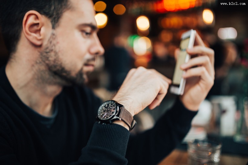 在咖啡厅使用苹果笔记本和手机的年轻男子图片