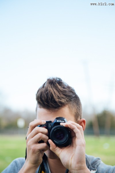 正在用相机拍照的青年图片
