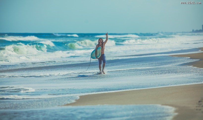 海边拿着冲浪板的人图片大全