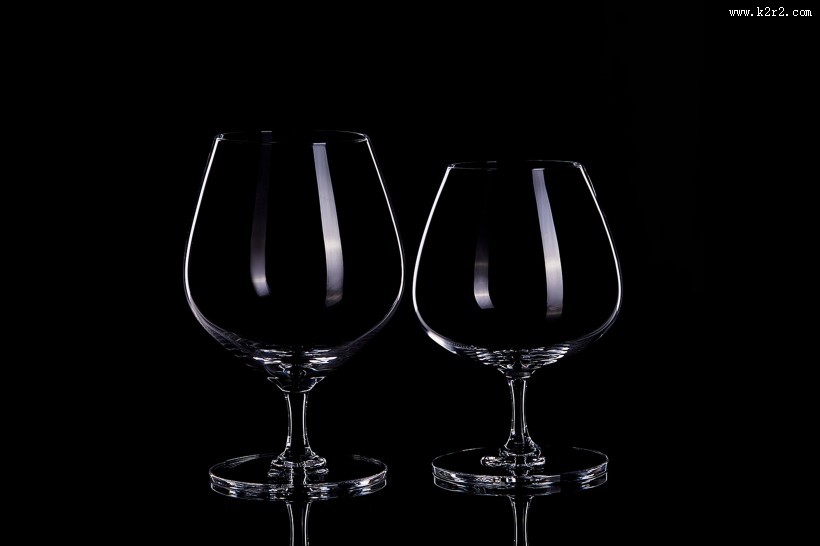 黑色背景透明红酒杯图片