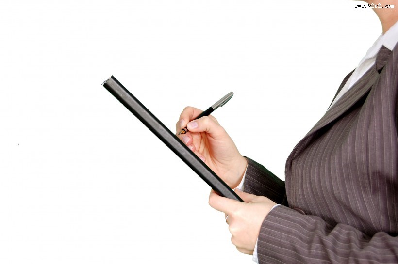 拿着笔书写的图片