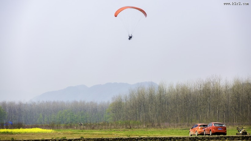 在天空悠闲飞行的滑翔伞图片